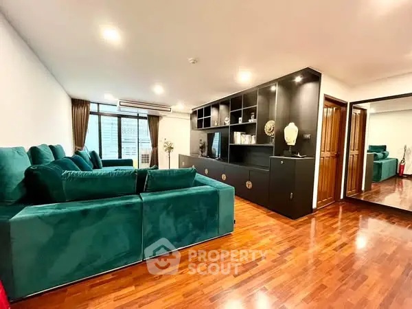 Spacious living room with elegant green sofa and modern built-in shelving