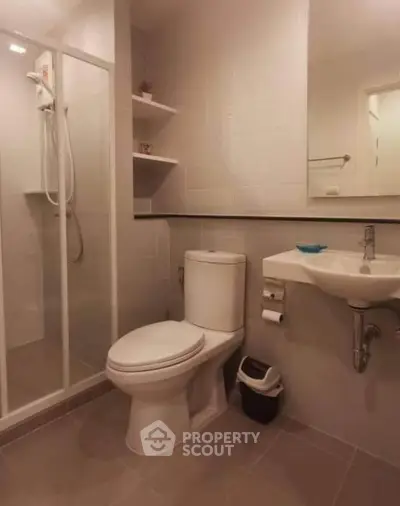 Modern bathroom with shower enclosure and sleek fixtures in a contemporary apartment.