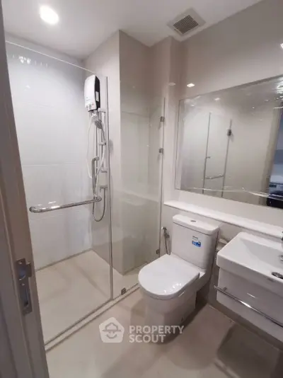 Modern bathroom with glass shower enclosure and sleek fixtures