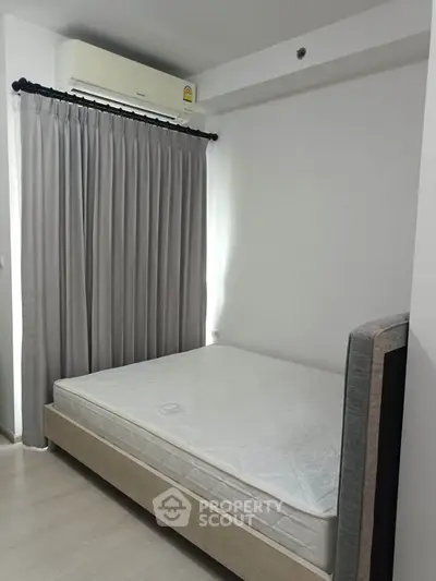 Modern bedroom with minimalist design featuring a comfortable bed and air conditioning.