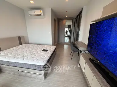 Modern bedroom with sleek design, featuring a comfortable bed, air conditioning, and a large TV for ultimate relaxation.