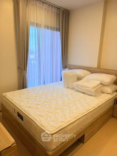 Cozy bedroom with natural light and modern furnishings, featuring a comfortable bed and elegant curtains.