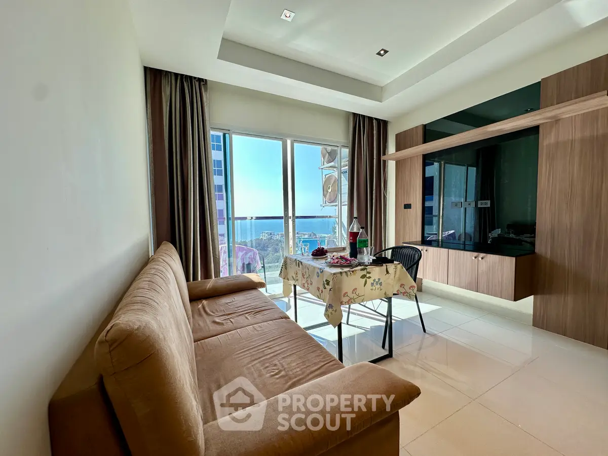 Modern living room with sea view, featuring a cozy sofa and dining area, perfect for relaxation and entertaining.