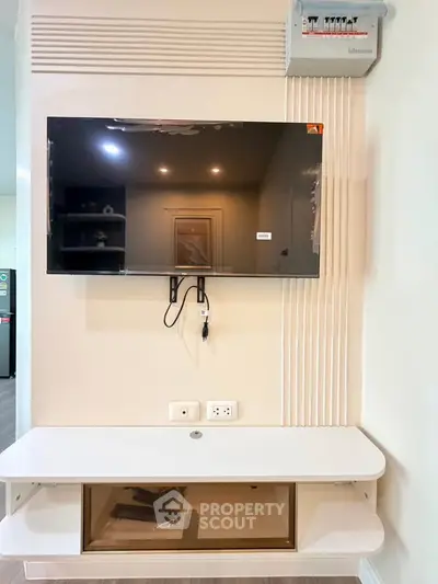 Modern living room with wall-mounted TV and sleek white console