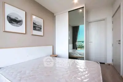 Modern bedroom with minimalist decor and large window offering natural light.