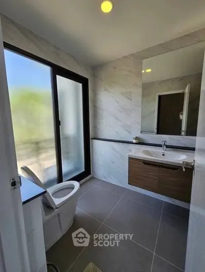 Modern bathroom with sleek design, featuring a large window and stylish vanity.