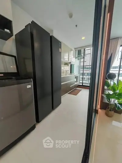 Modern kitchen with sleek appliances and large windows for natural light.