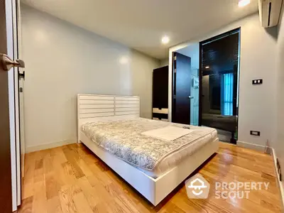 Modern bedroom with wooden flooring and minimalist design in a stylish apartment.