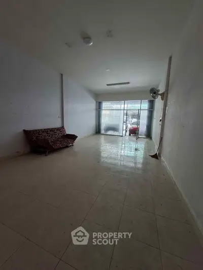 Spacious unfurnished living room with tiled floor and large window for natural light.