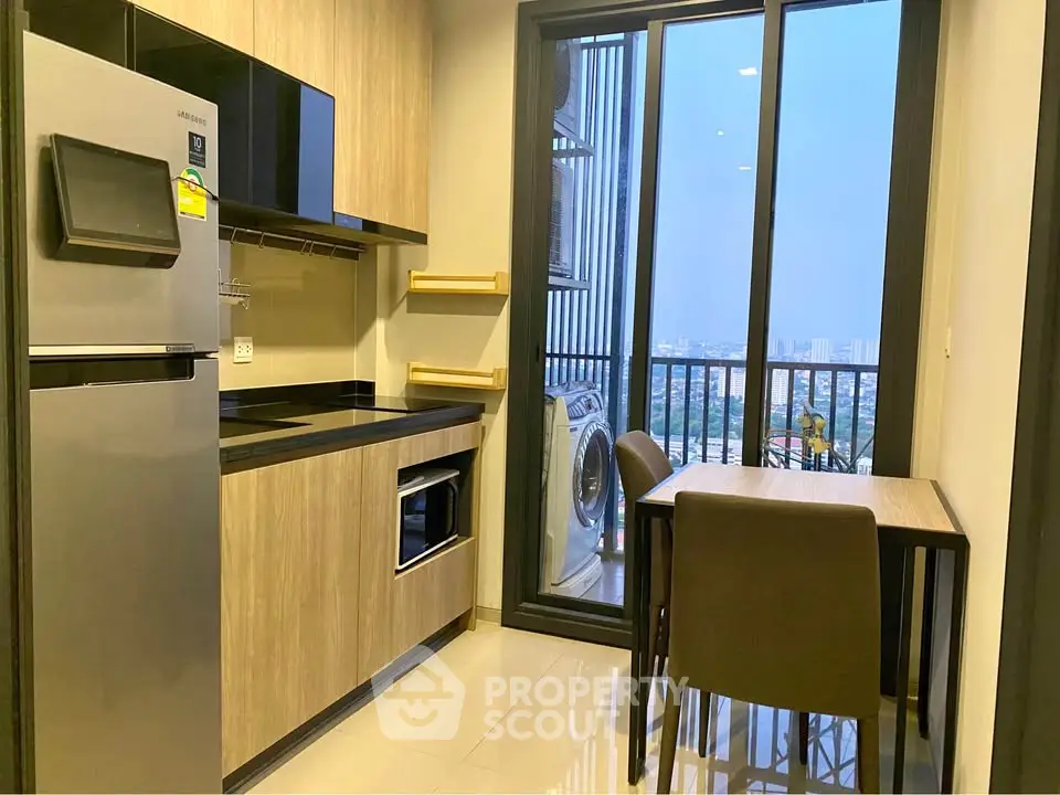 Modern kitchen with sleek appliances and balcony view in urban apartment