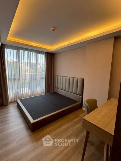 Modern bedroom with sleek design, featuring a large window and elegant lighting.