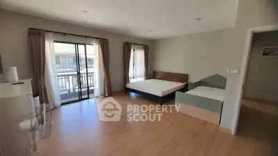 Spacious bedroom with balcony access and modern furnishings