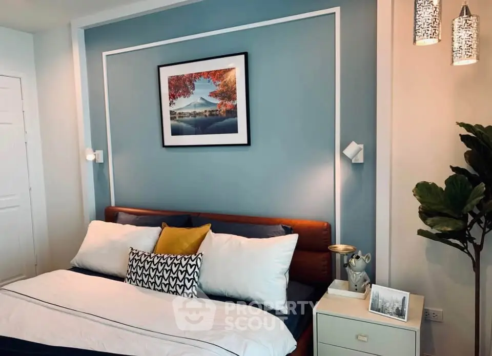 Stylish bedroom with modern decor and cozy ambiance, featuring elegant lighting and a framed artwork above the bed.