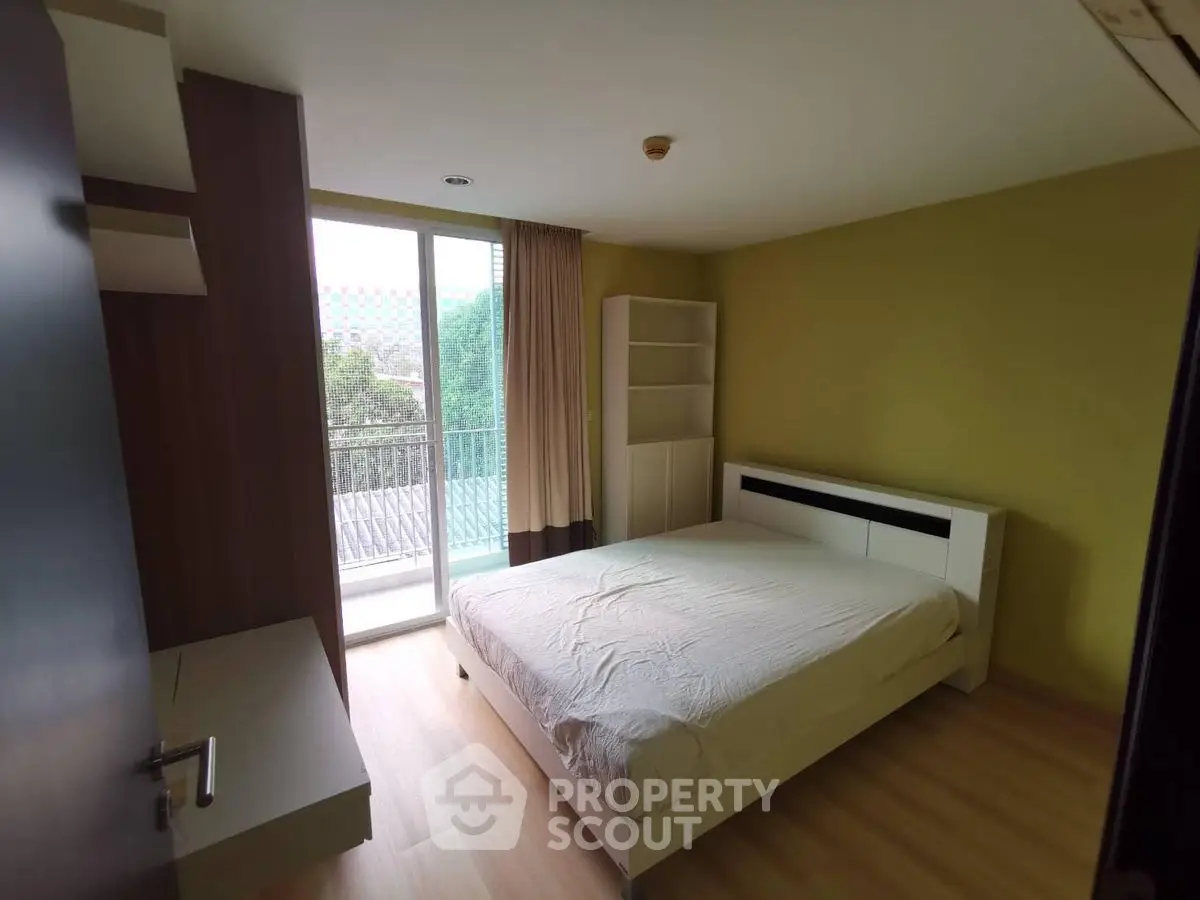 Spacious bedroom with balcony access and modern furnishings