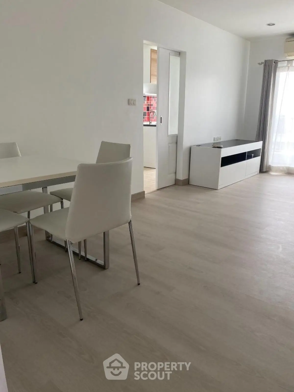 Spacious modern dining area with sleek white furniture and natural light