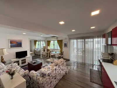 Spacious open-plan living room with modern decor and large windows for natural light.