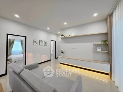 Modern living room with sleek design and neutral tones, featuring a cozy gray sofa and stylish shelving.