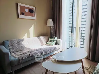 Chic living room with modern sofa and stylish decor, featuring floor-to-ceiling windows and a cozy ambiance.