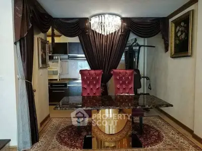 Luxurious dining area with elegant chandelier and plush chairs in a sophisticated home setting.
