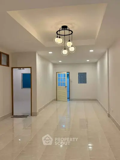 Spacious modern living room with elegant lighting and glossy tiled flooring.