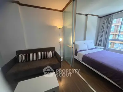 Modern bedroom with cozy seating area and large window view