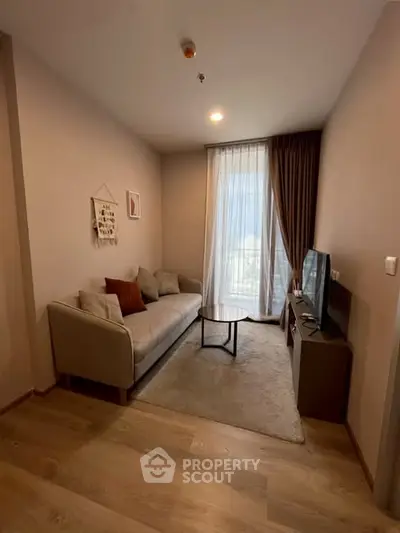 Cozy living room with modern decor and natural light, perfect for relaxation.