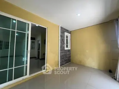 Spacious room with sliding glass doors and modern tile flooring, perfect for versatile living space.
