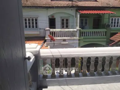 Charming balcony view of traditional homes with tiled roofs and ornate railings.
