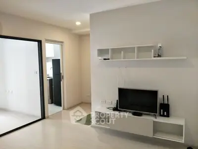 Modern living room with sleek TV setup and open kitchen view