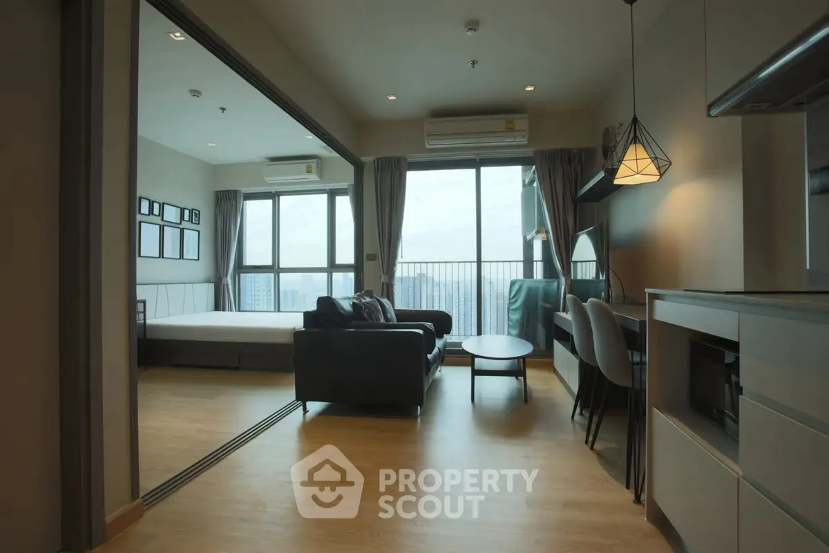 Modern open-plan living room with large windows and city view