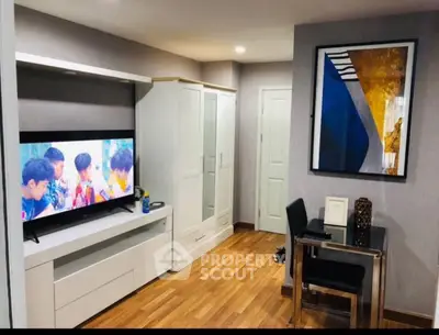Modern living room with sleek furniture and stylish decor, featuring a flat-screen TV and contemporary artwork.