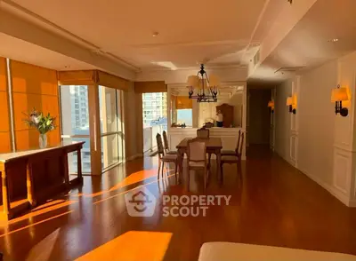 Spacious sunlit living room with elegant dining area and large windows offering city views.