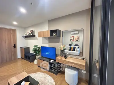 Modern living room with stylish furniture and decor, featuring a TV and wooden accents.
