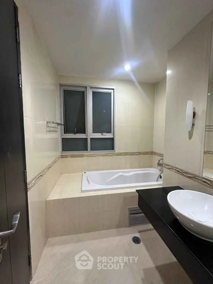 Modern bathroom with bathtub and sleek fixtures in a contemporary apartment.