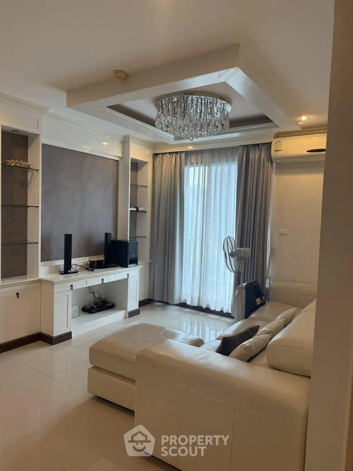 Luxurious living room with elegant chandelier and modern furnishings in a stylish apartment.