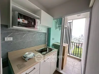 Compact kitchen with balcony view in modern apartment