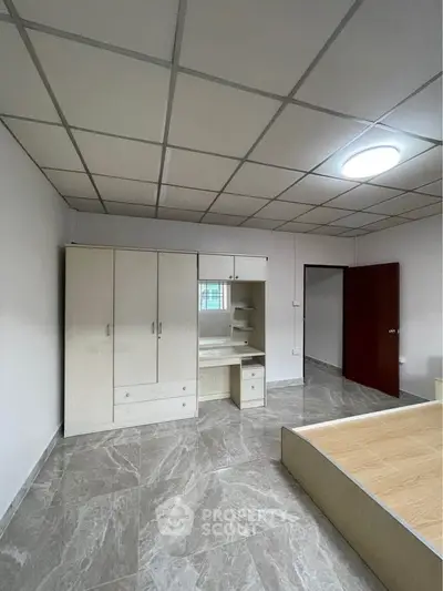 Spacious bedroom with modern wardrobe and sleek tiled flooring