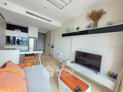 Modern living room with open kitchen, stylish decor, and natural light