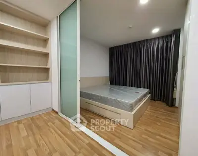 Modern bedroom with wooden flooring and built-in shelving