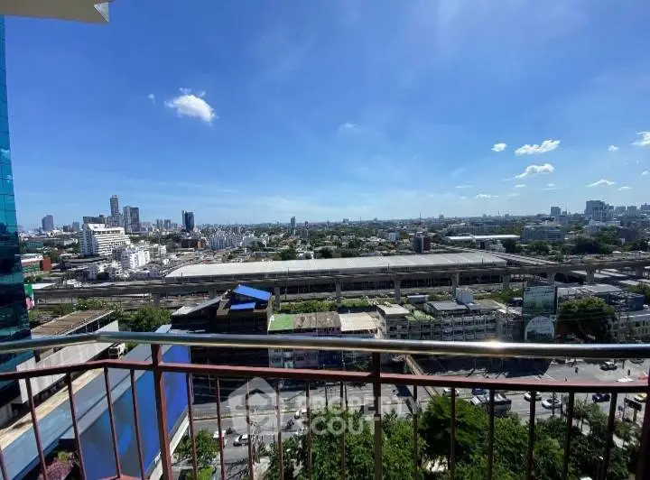 Stunning cityscape view from a high-rise balcony with clear blue skies.