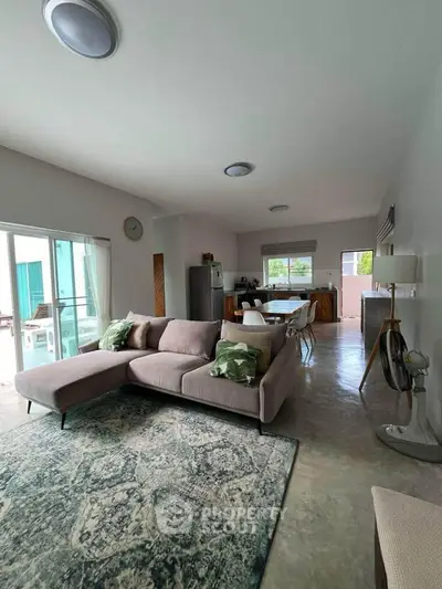 Spacious open-plan living room with modern decor and natural light