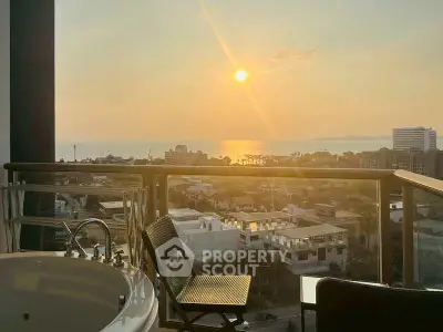 Stunning sunset view from a balcony with jacuzzi overlooking the city and ocean.