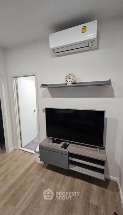 Modern living room with sleek TV stand and air conditioning unit, perfect for cozy entertainment.