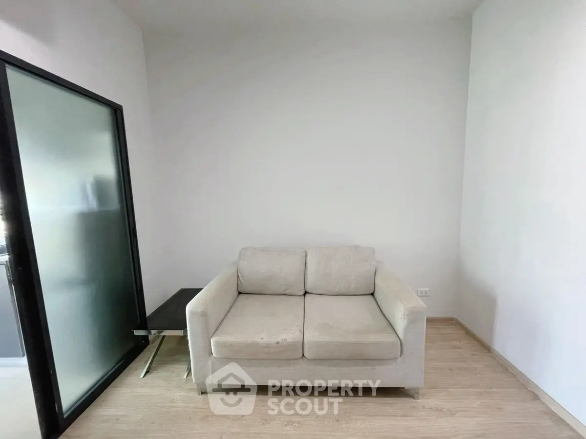 Cozy small living area with modern armchair and side table, perfect for compact spaces.