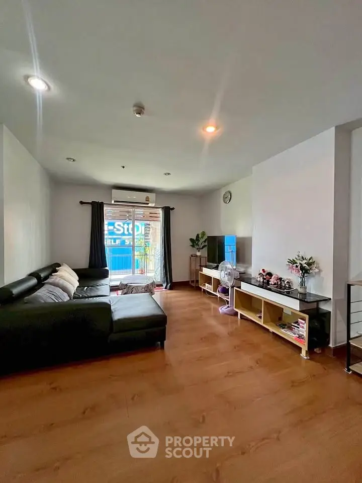 Spacious living room with modern decor and large window for natural light.