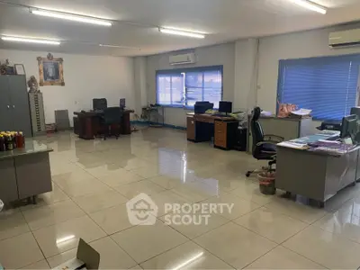 Spacious office interior with modern desks and ample natural light, ideal for a productive work environment.