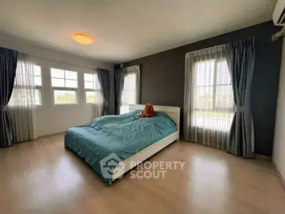 Spacious bedroom with large windows and modern decor