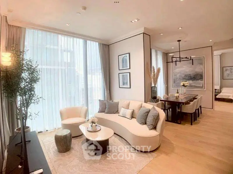 Luxurious open-plan living and dining area with elegant decor and large windows.