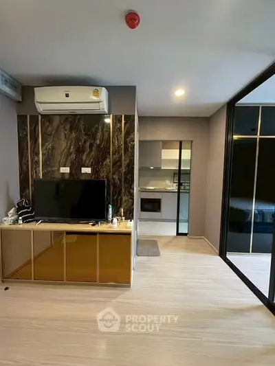 Modern living room with sleek design and integrated kitchen area, featuring stylish decor and ample natural light.