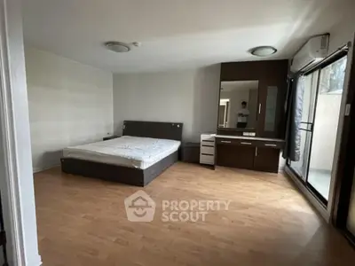 Spacious bedroom with large bed, ample natural light, and sleek wooden flooring, ideal for relaxation and comfort in a modern home.